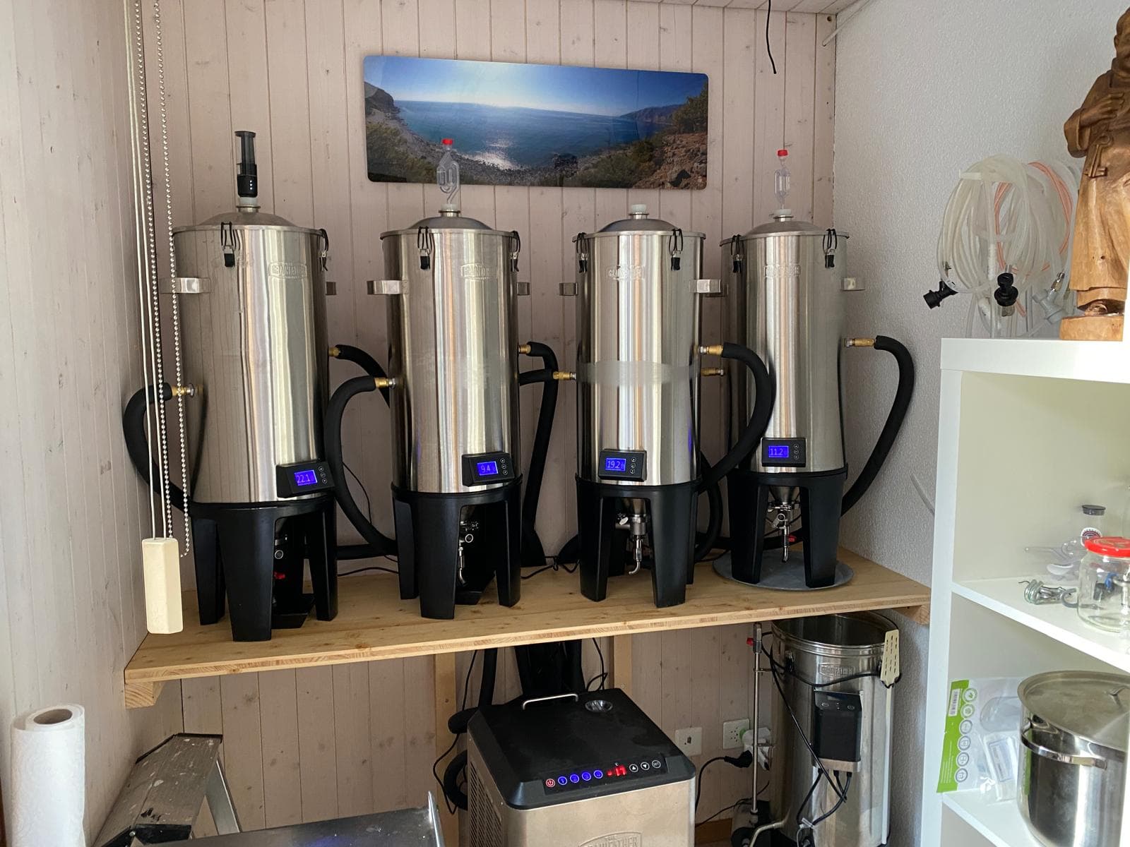 Four Grainfather fermenters with glowing digital displays
