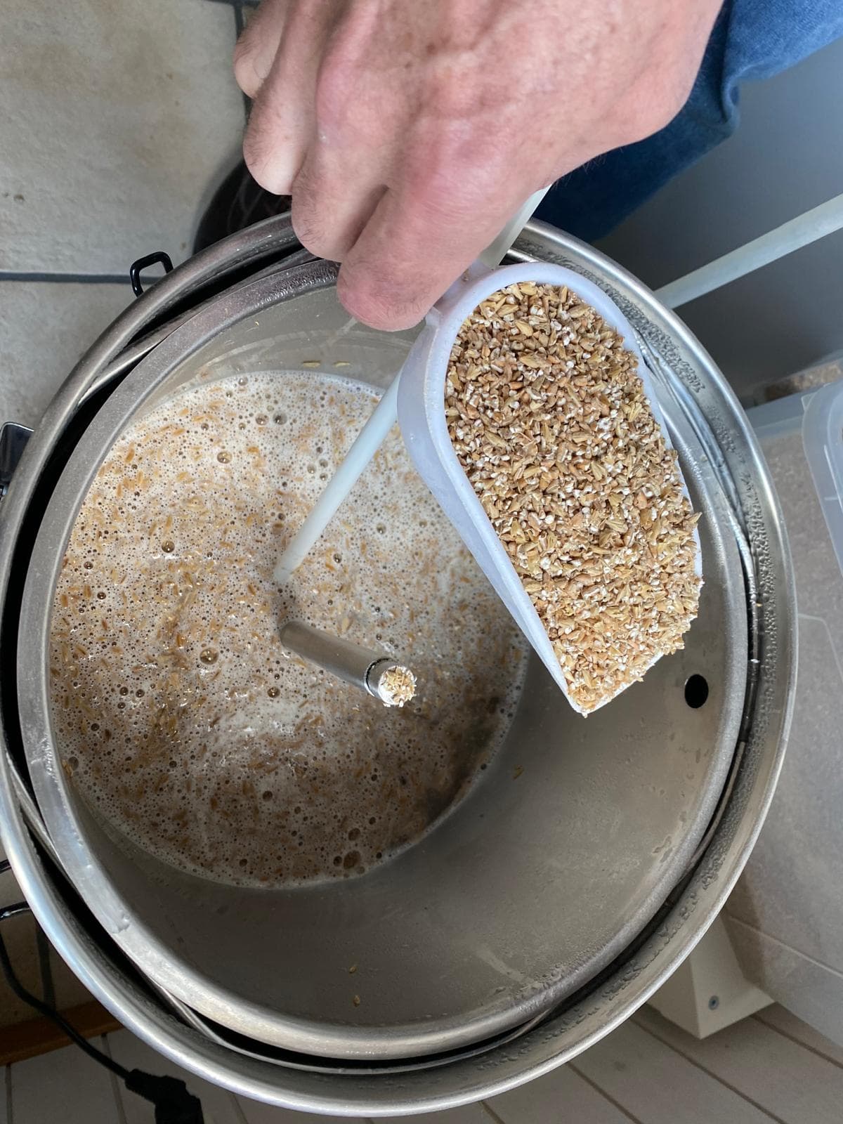 Gerhard pouring crushed malt into the Grainfather mash tun