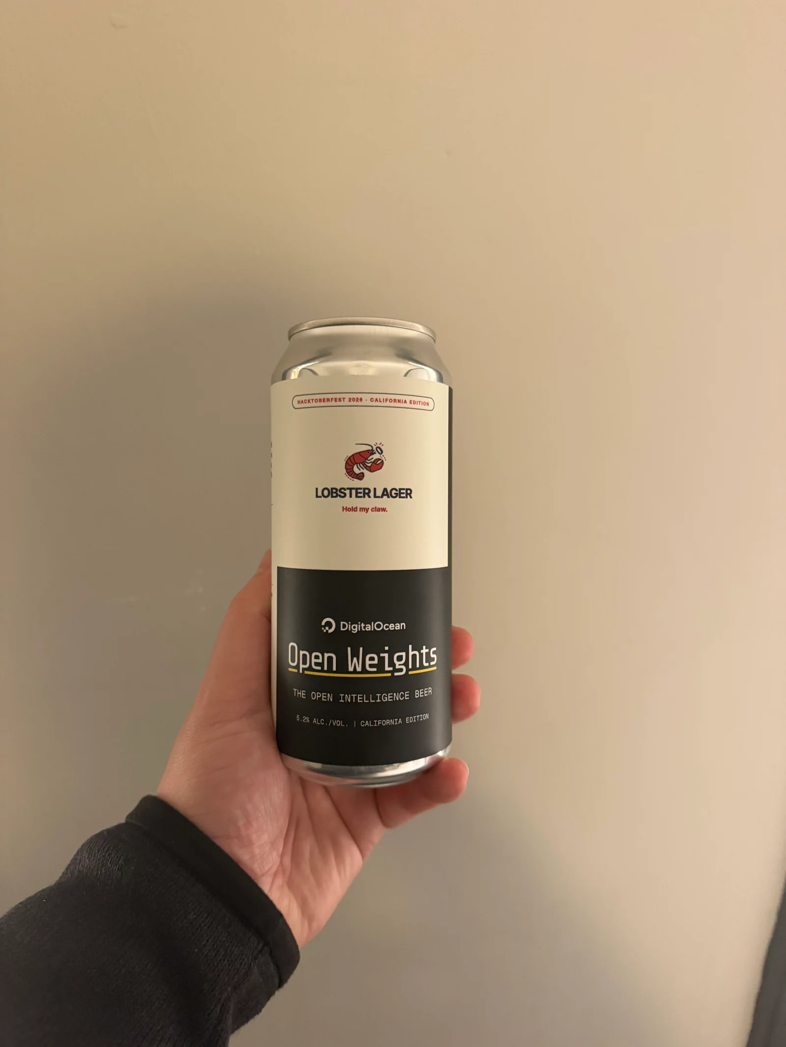 A hand holding the finished Lobster Lager DigitalOcean Open Weights can in San Francisco